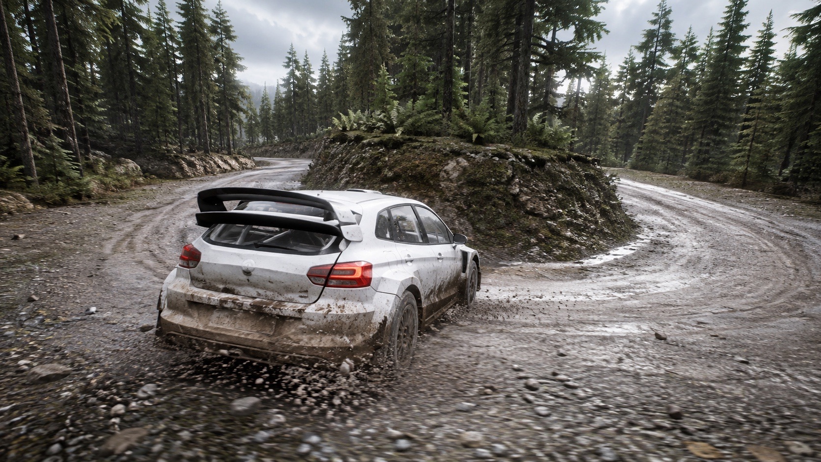 A rally car balancing a four-wheel drift through a damp forest hairpin